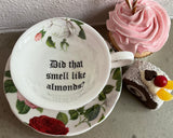 "Did that smell like almonds?" cup and saucer set, porcelain